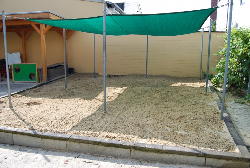 ... ein Sandkasten mit vielen verschiedenen Sandspielsachen.